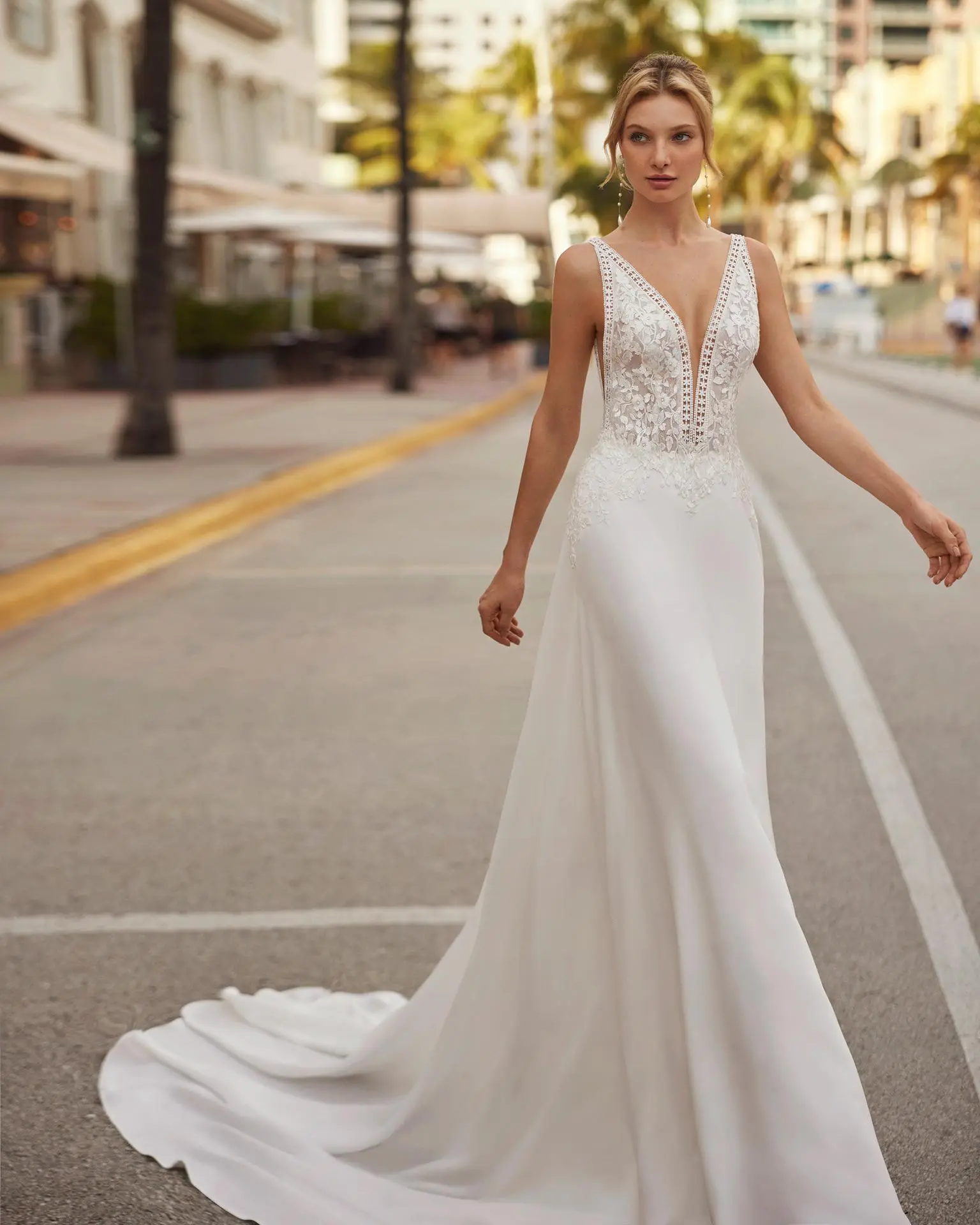 Robe de mariée élégante en crêpe avec décolleté en V et dos ouvert, ornée de dentelle et perles