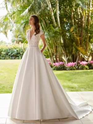 Robe de mariée princesse en satin et dentelle, jupe volumineuse avec poches, encolure en V, dos en tulle à pois, manches courtes