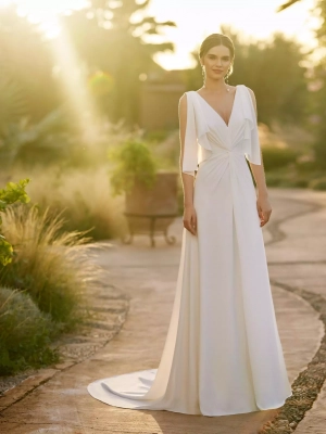 Robe de mariée fluide en crêpe avec décolleté en V, dos plongeant et manches papillon, ornée d'un nœud et de volants légers